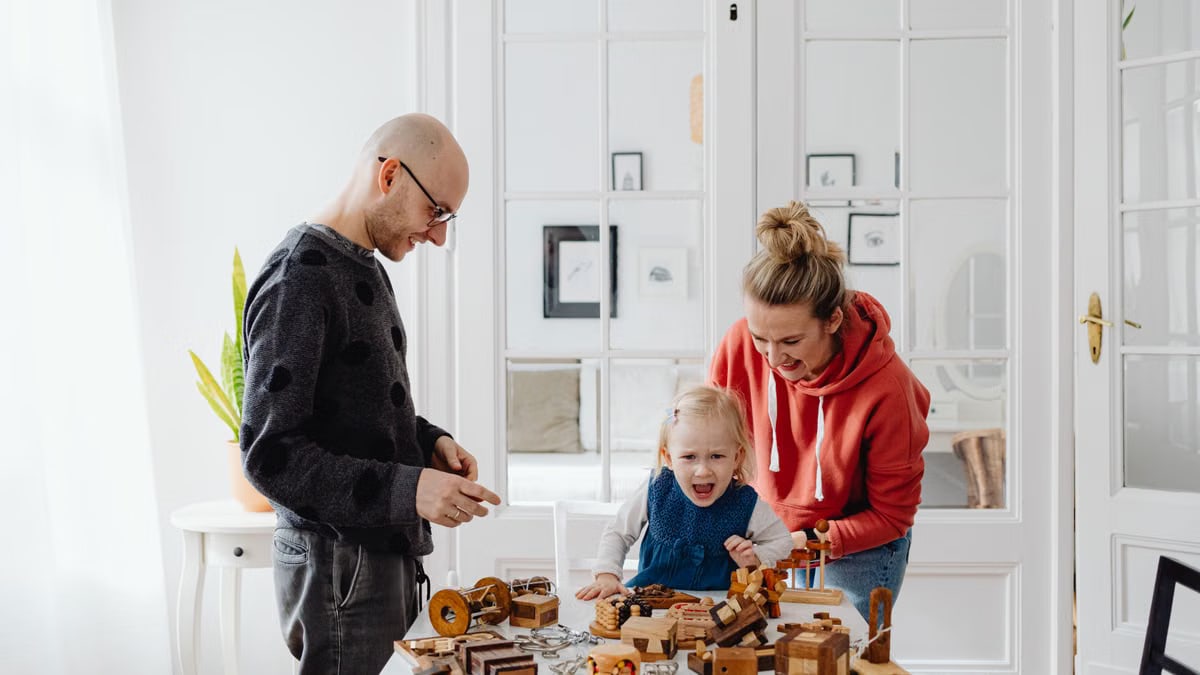 Happy family playing with wooden toys at home, creating joyful memories during leisure time.